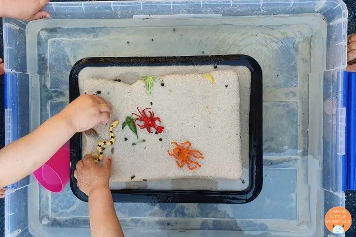 A block of sand, melting away and revealing toys frozen inside