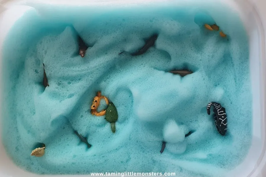 A bin filled with blue foam and sea creature toys